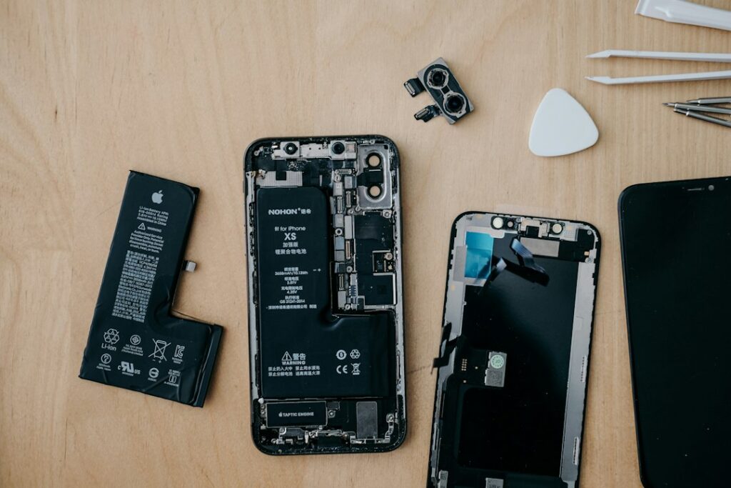 Close-up of a smartphone being repaired with precision tools